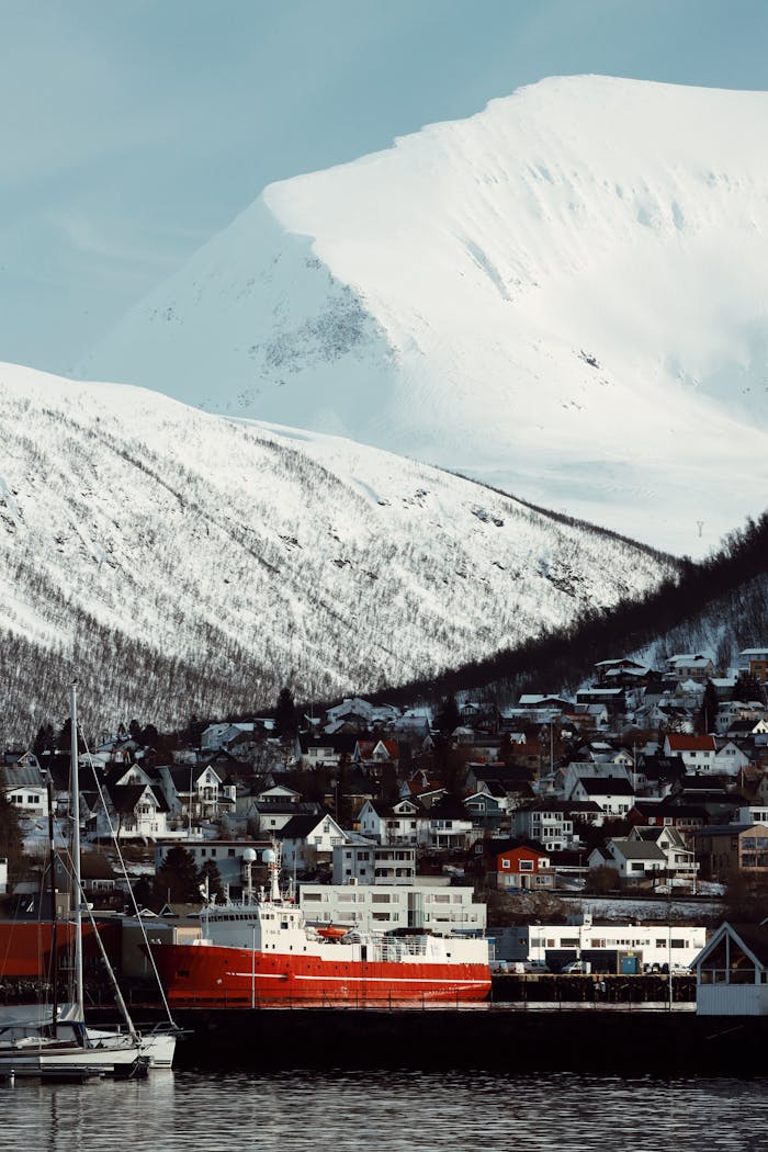 Capture of Tromsø, Norway with a vibrant red ship, snowy mountains, and Nordic architecture.